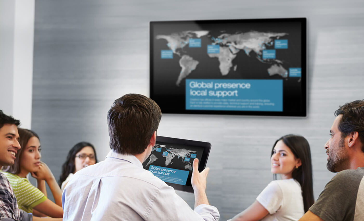 Man giving a presentation using a tablet and TV